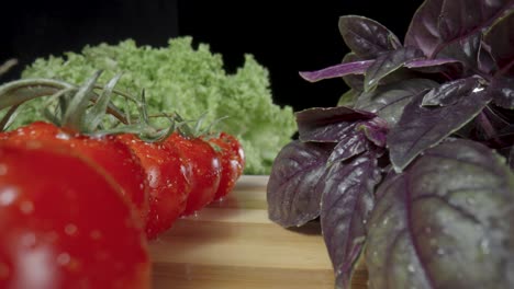 fresh tomatoes, basil, and lettuce on a wooden board