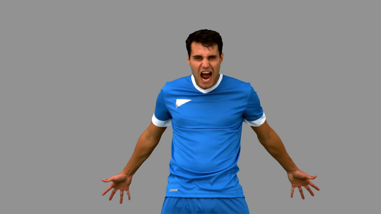 Angry football player holding his head on grey screen
