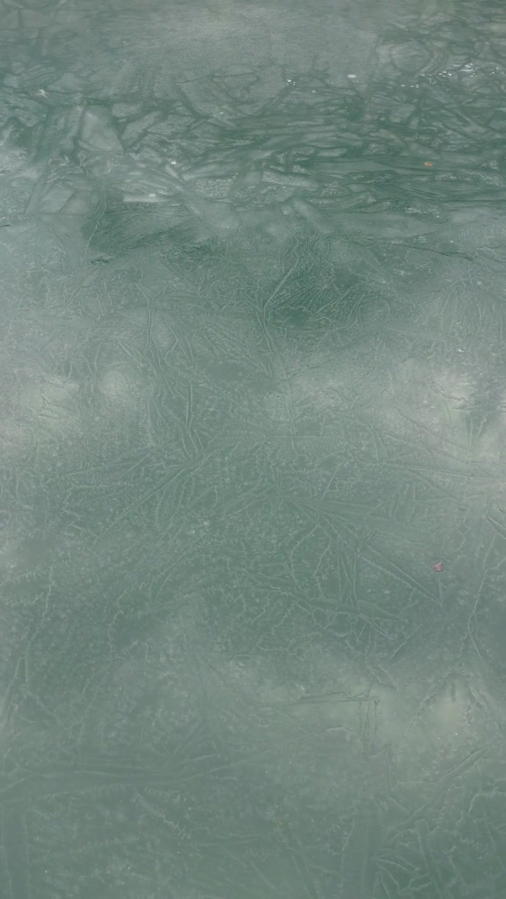 Thin layer of fresh frozen ice water intricate patterns and soft turquoise or pale blue hues