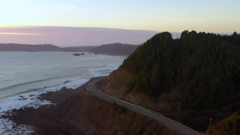 Cars-driving-on-beautiful-scenic-bending-road-101-at-Port-Orford-at-evening,-Oregon