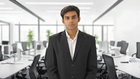 serious indian businessman looking at the camera