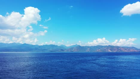 a wonderful nature in indonesia with blue calm ocean and cloudy blue sky above - wide shot