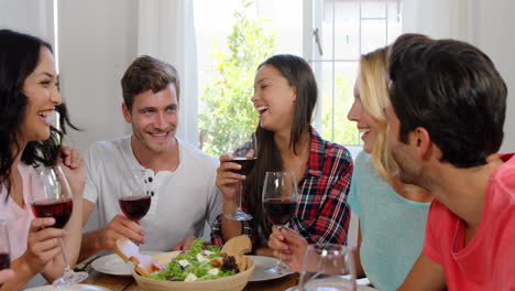 amigos felices comiendo un almuerzo saludable con vino