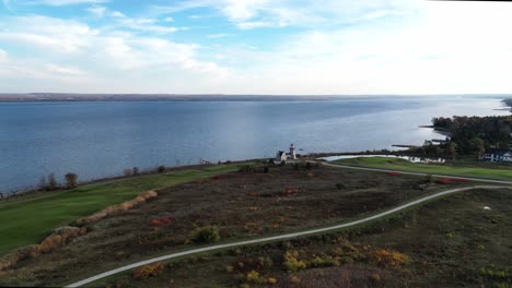 Toma-Aérea-De-Un-Campo-De-Golf-A-Lo-Largo-De-La-Orilla-De-Un-Gran-Lago