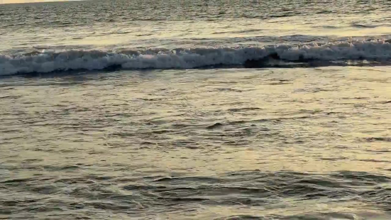 Onde dorate dell'oceano che si infrangono e si ritirano al tramonto