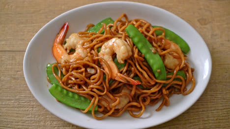 stir-fried yakisoba noodles with green peas and shrimps - asian food style