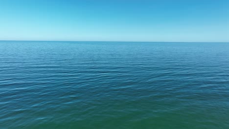 low drone flight over the calm glistering waters of the atlantic ocean.