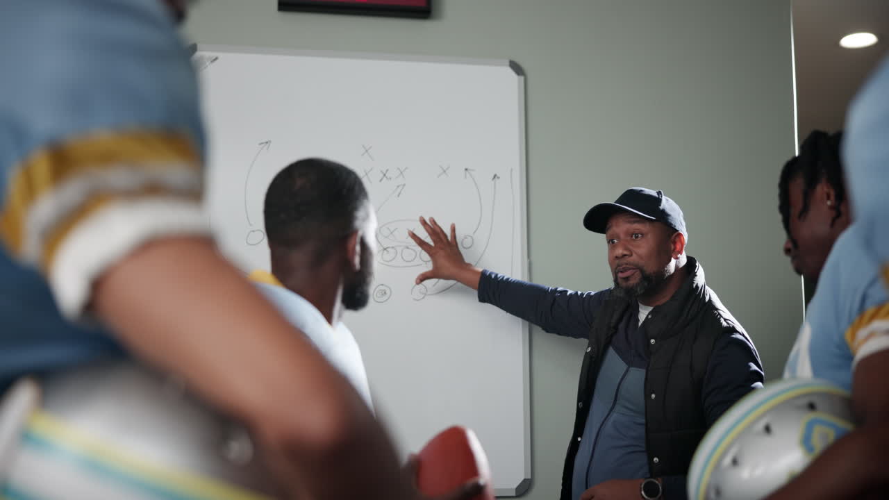 Football coach discussing strategy with his team