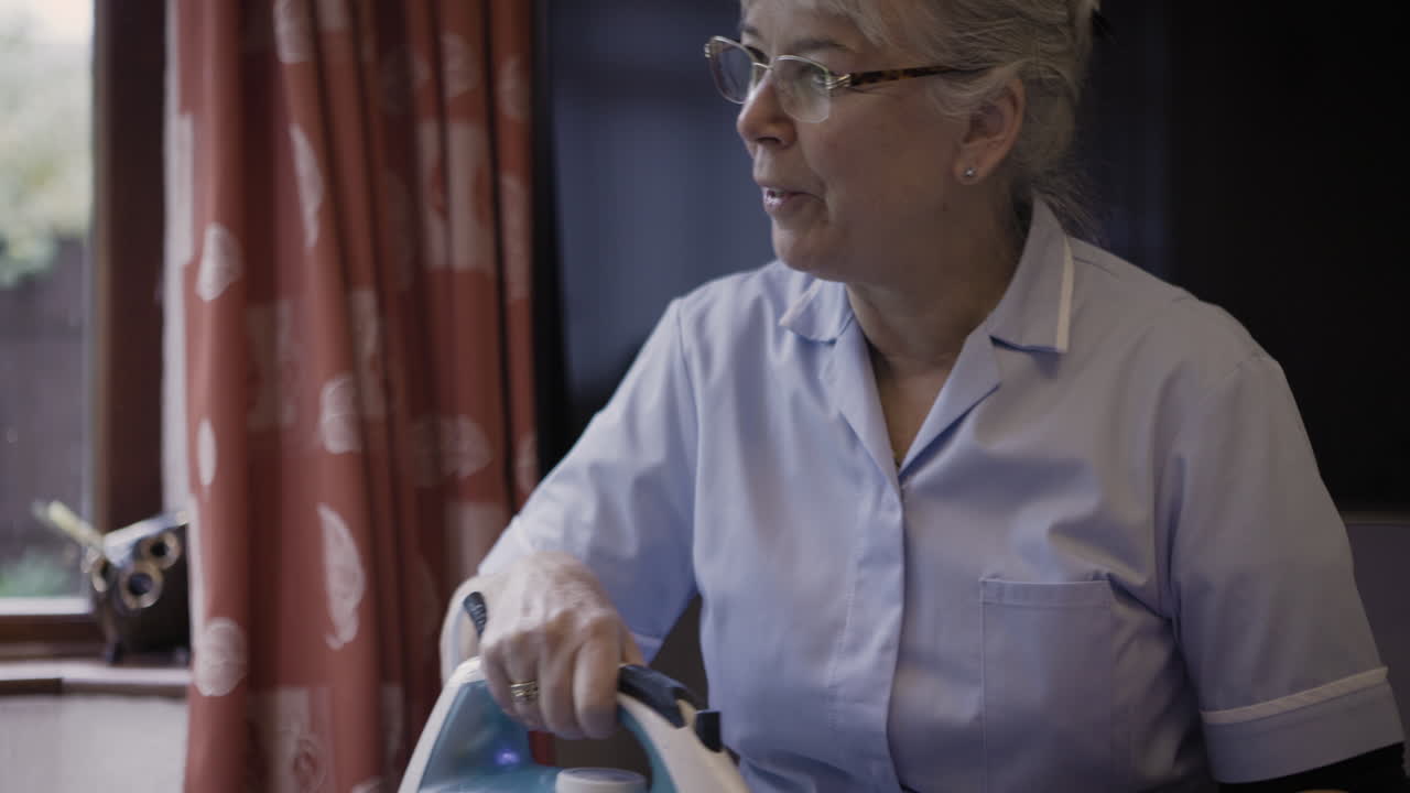 Woman ironing clothes at home