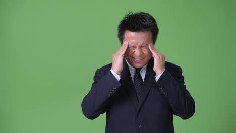 녹색 배경에 성숙한 일본 사업가