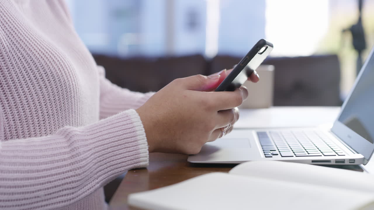 mujer usando teléfono inteligente y portátil en casa