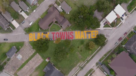 Bird-eye-view-of-a-large-"Black-Towns-Matter"-sign-painted-on-street-in-Houston-Historical-independence-Heights-district