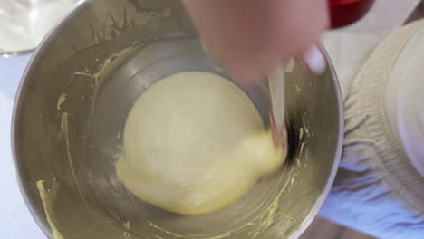 mixing of creamy cake ingredients by hand in metal bowl home baking pov