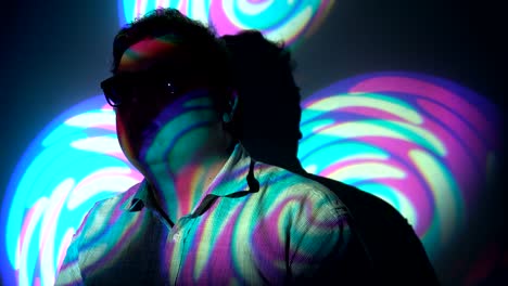 retrato de un hombre gordo en un haz de luz multicolor.