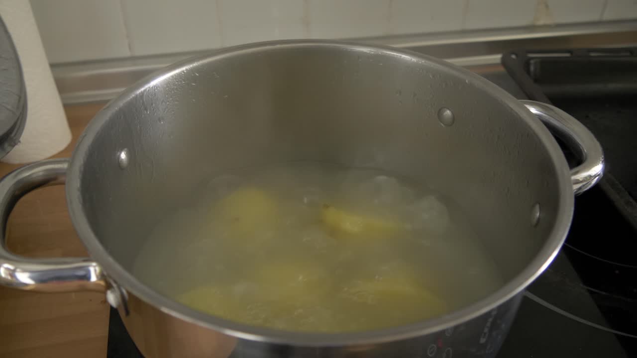 abriendo la parte superior de una olla con patatas hirviendo