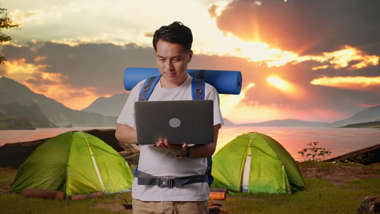 Man working on laptop while camping
