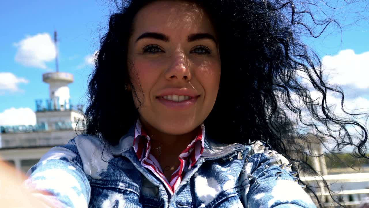 una mujer feliz y despreocupada sostiene la cámara en las manos y gira a su alrededor