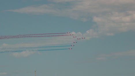 tracking shot of the alpha jets of the patrouille de france performing with coloured smoke