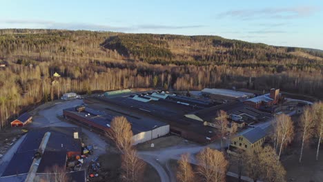 Drone-rising-over-industry-building-in-Bongbro,-Sweden