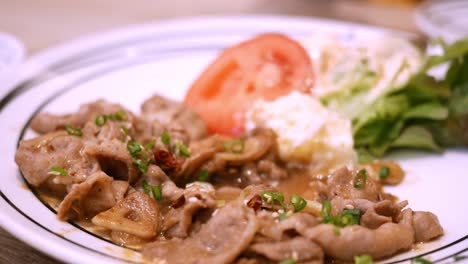 detalle de los palillos para quitar la comida del plato de bulgogi de cerdo picante