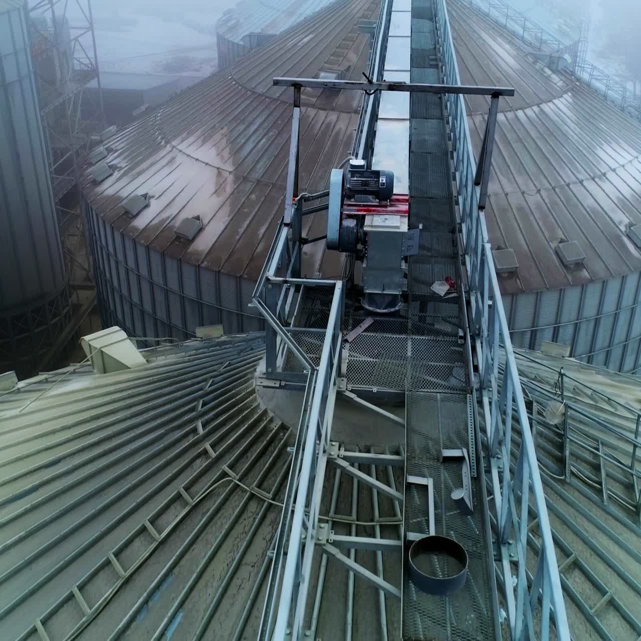 Metal passages between the huge tanks of grain elevator. Number of granary elevator cisterns standing close to each other at agribusiness plant
