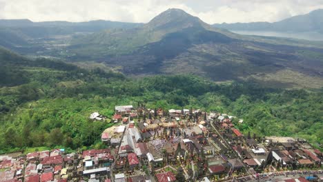 drone shot of religious hindu temple tuluk biyu with volcano batur at the background located in kintamani region