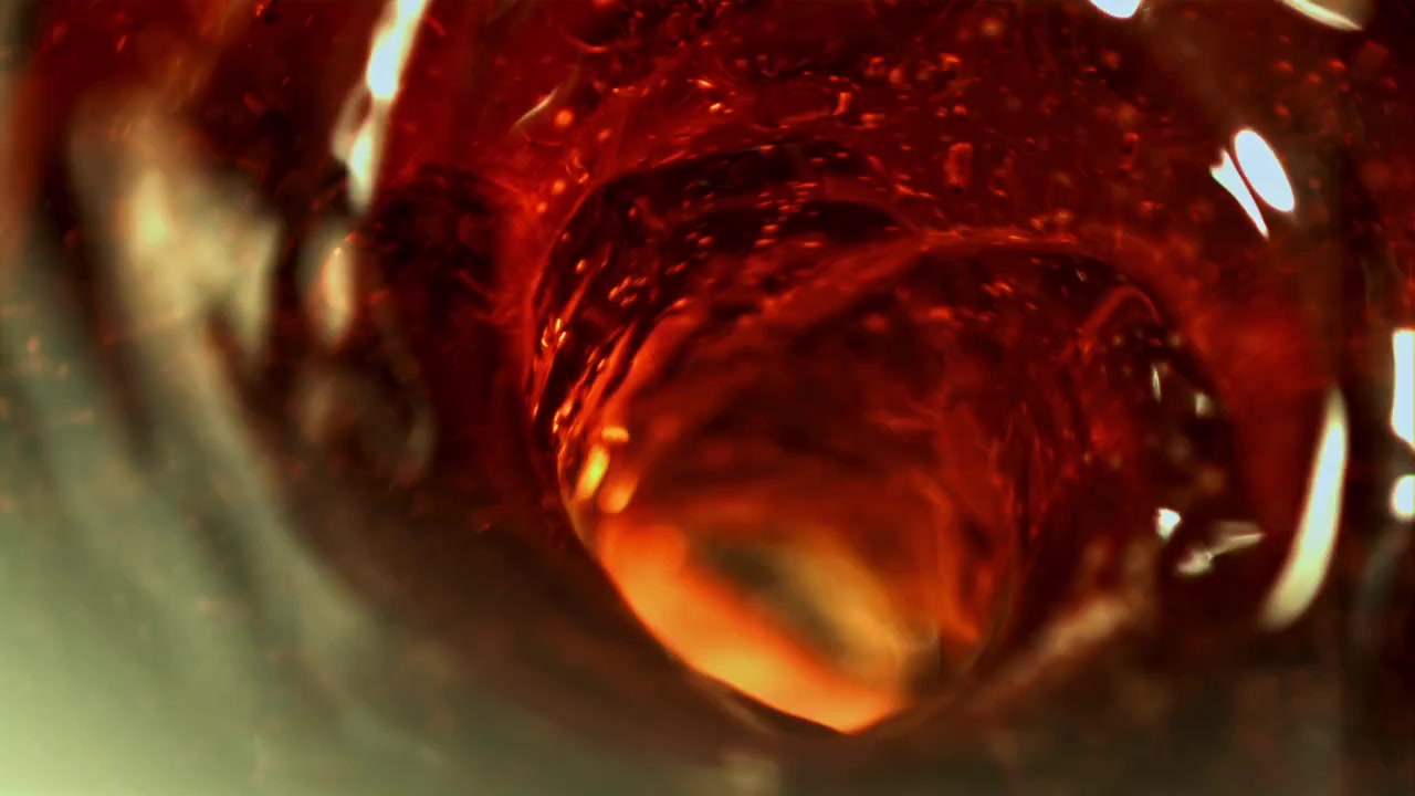 Macro di liquido rosso astratto che vortica in un vortice dinamico.