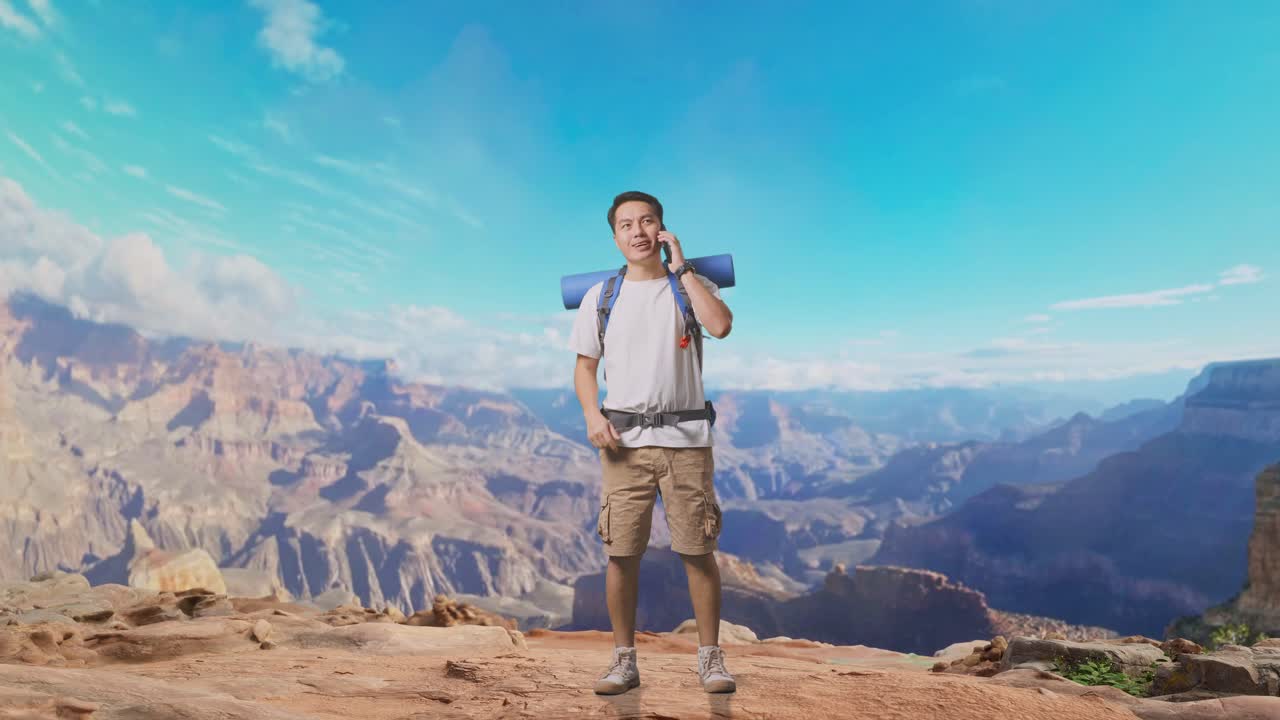 Full Body Of Asian Male Hiker With Mountaineering Backpack Smiling And Talking On Smartphone While Traveling At The Top Of Mountain