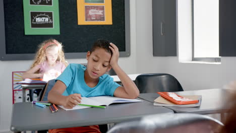 biracial boy appears frustrated with homework in a classroom setting in school