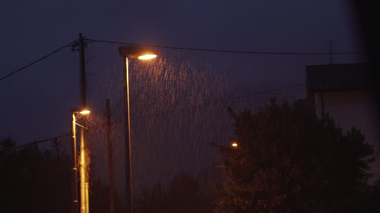 cerrar las lámparas de la calle por la noche, fuerte lluvia, cielo oscuro