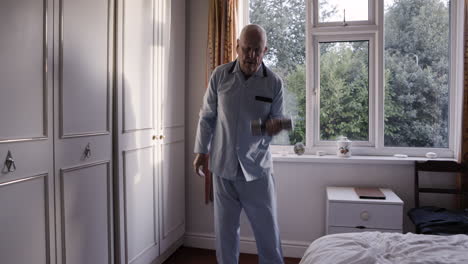 elderly man exercising with dumbbells in his bedroom