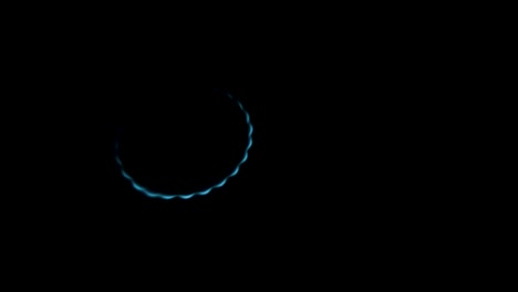 burning gas stove hob, blue flames macro close-up in the dark on a black background. gas is switching on, apearing blue flame. gas stove on isolated on a black background.