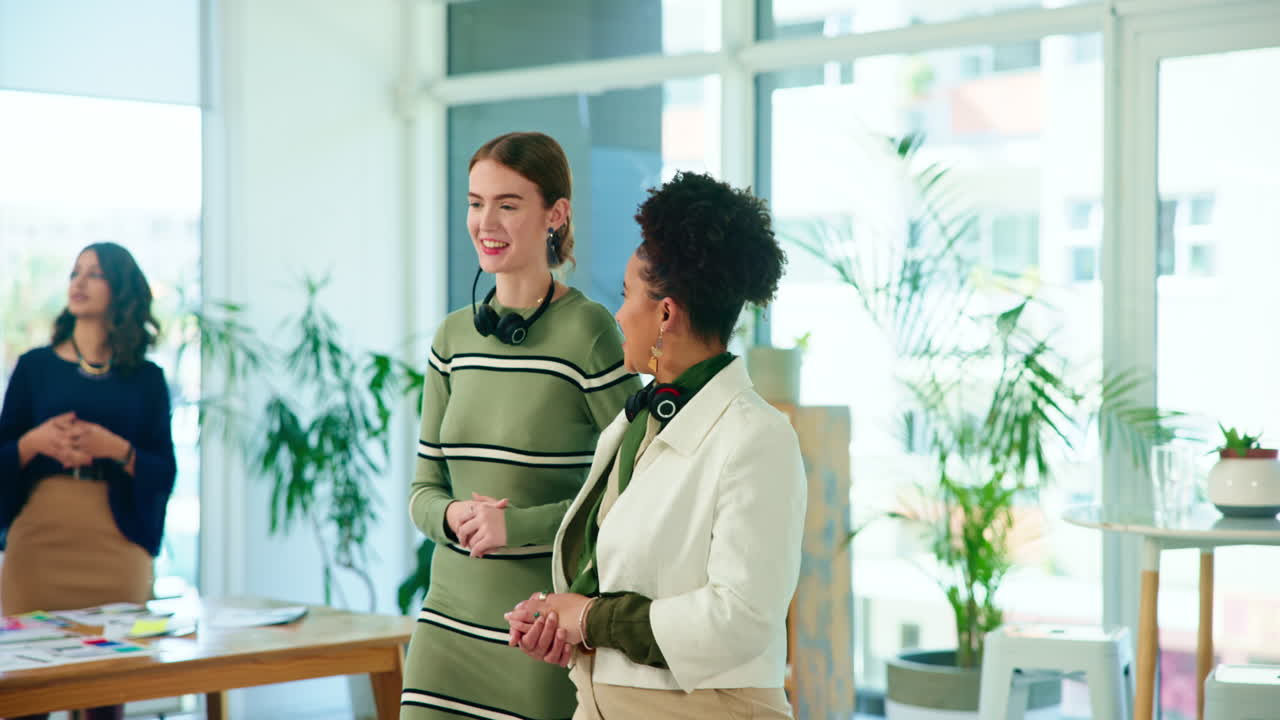 due donne che ridono e parlano in un ufficio