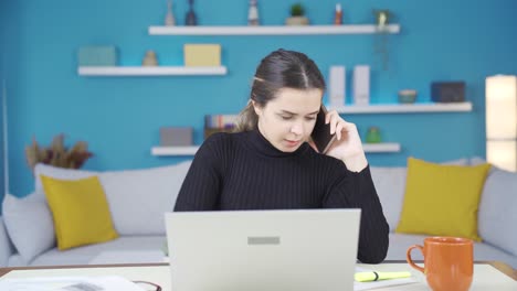 una joven empresaria que trabaja en una oficina en casa tiene una entrevista de trabajo por teléfono.