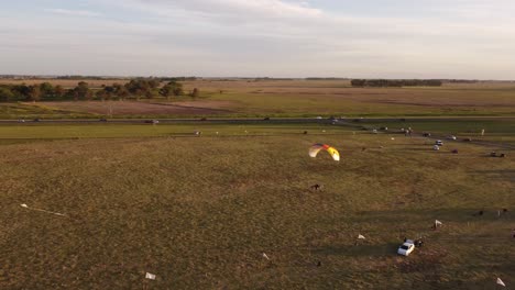 Motorisierter-Gleitschirm,-Der-Bei-Sonnenuntergang-In-Geringer-Höhe-über-Ländliche-Felder-Fliegt,-Argentinien