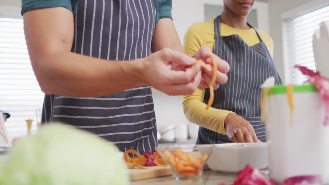 video de la sección media de una pareja diversa preparando comida, bebiendo vino y divirtiéndose en la cocina