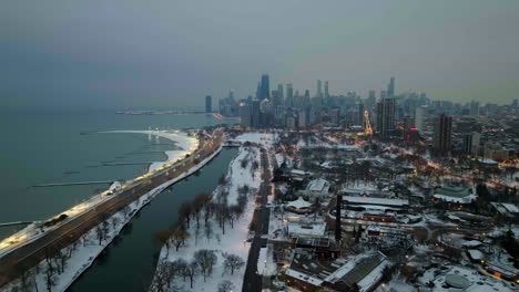 parque lincoln cubierto de nieve y el horizonte nebuloso del lado norte cercano de chicago - vista aérea