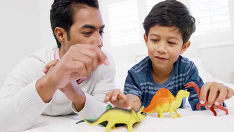 Father-and-son-playing-with-toys-on-bed-in-the-bedroom