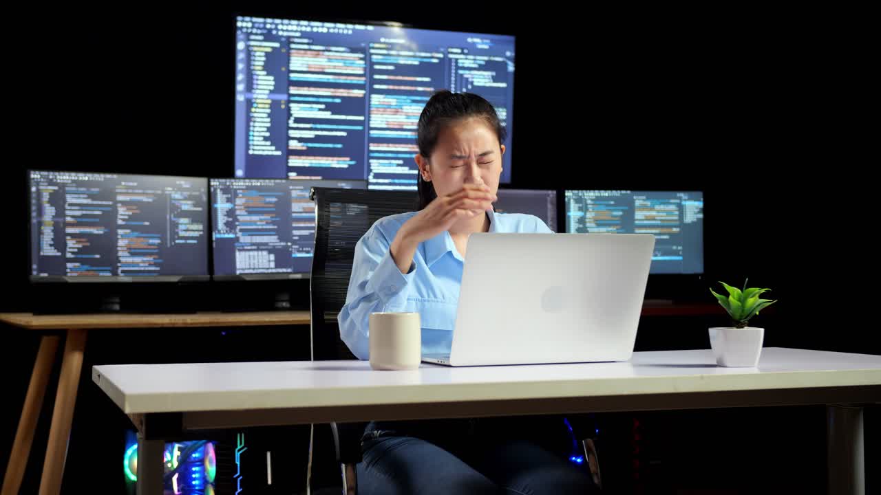 Asian Female Programmer Having A Headache While Writing Code By A Laptop Using Multiple Monitors Showing Database On Terminal Window Desktops In The Office