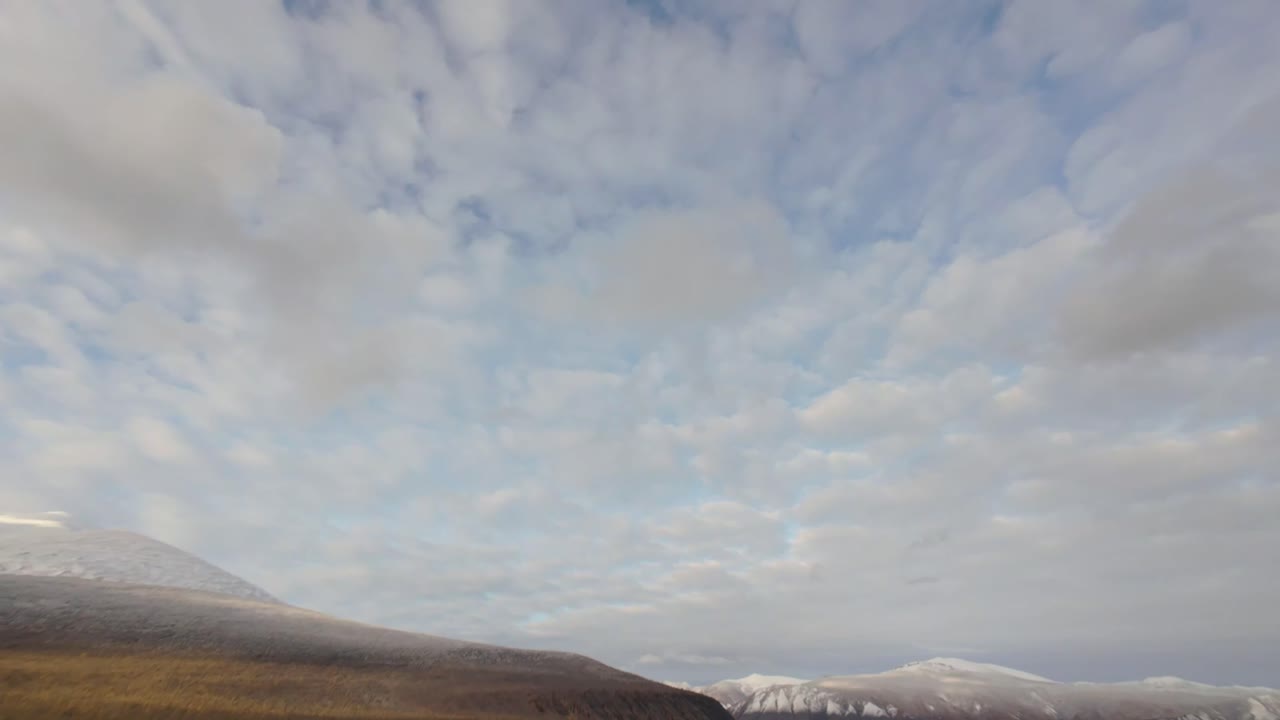 Fly over the stunning wilderness of Yakutia, showcasing its unique terrains, expansive skies, and rugged mountains, capturing nature’s untamed beauty in an enchanting atmosphere.