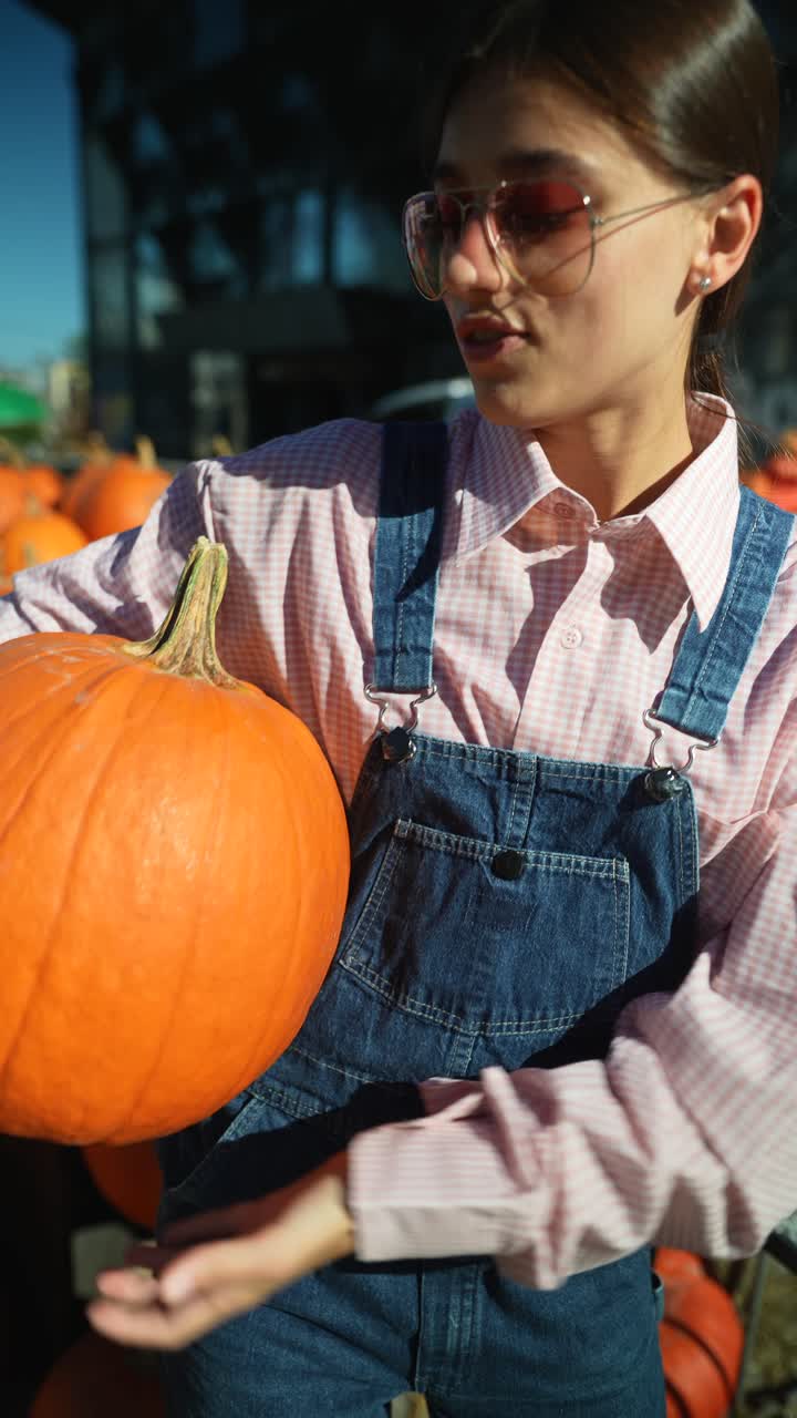 가을 시장 에서 호박 을 들고 있는 여자