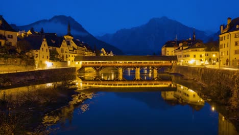 Historic Covered Bridge and Town at Night with Mountain Backdrop