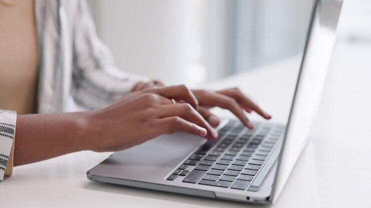 Hände tippen auf einer Laptoptastatur
