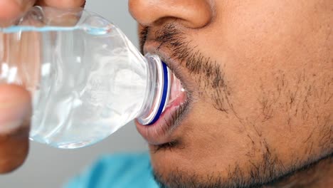 persona bebiendo agua de una botella de plástico