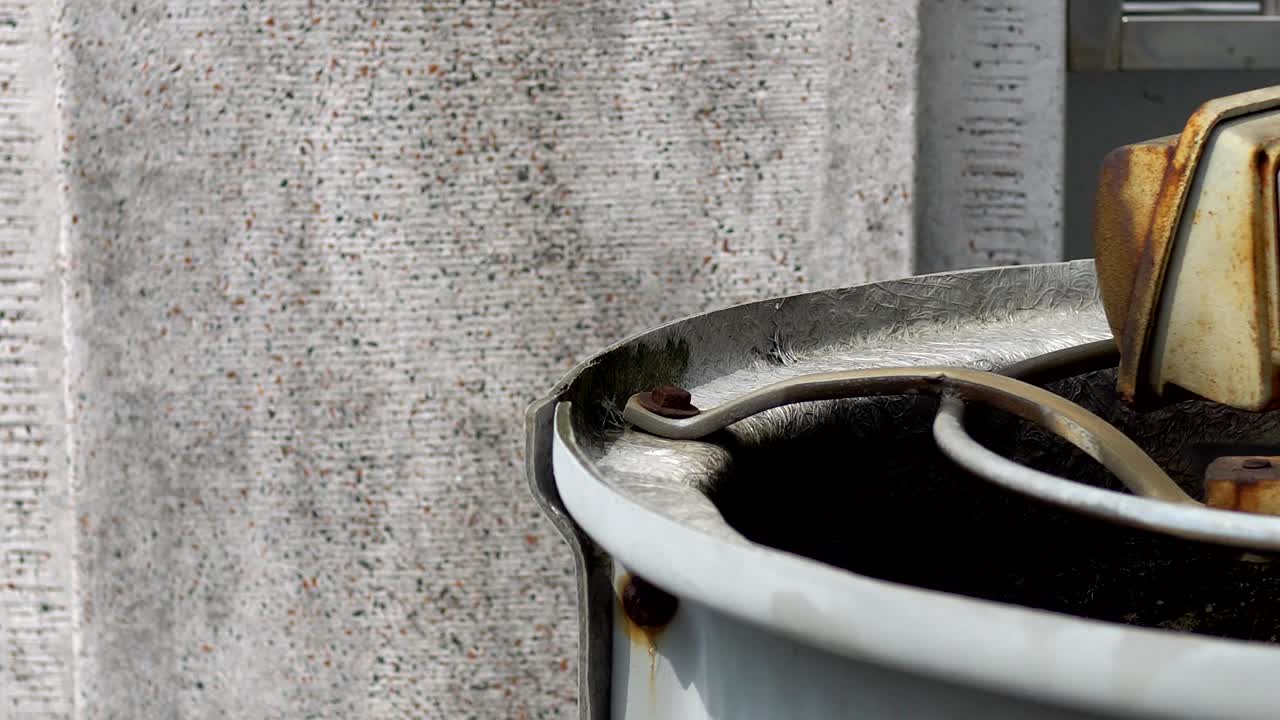 3 phase induction motor. The function is to drain or pump water. The exterior is old and rusty. The subject is on the right.