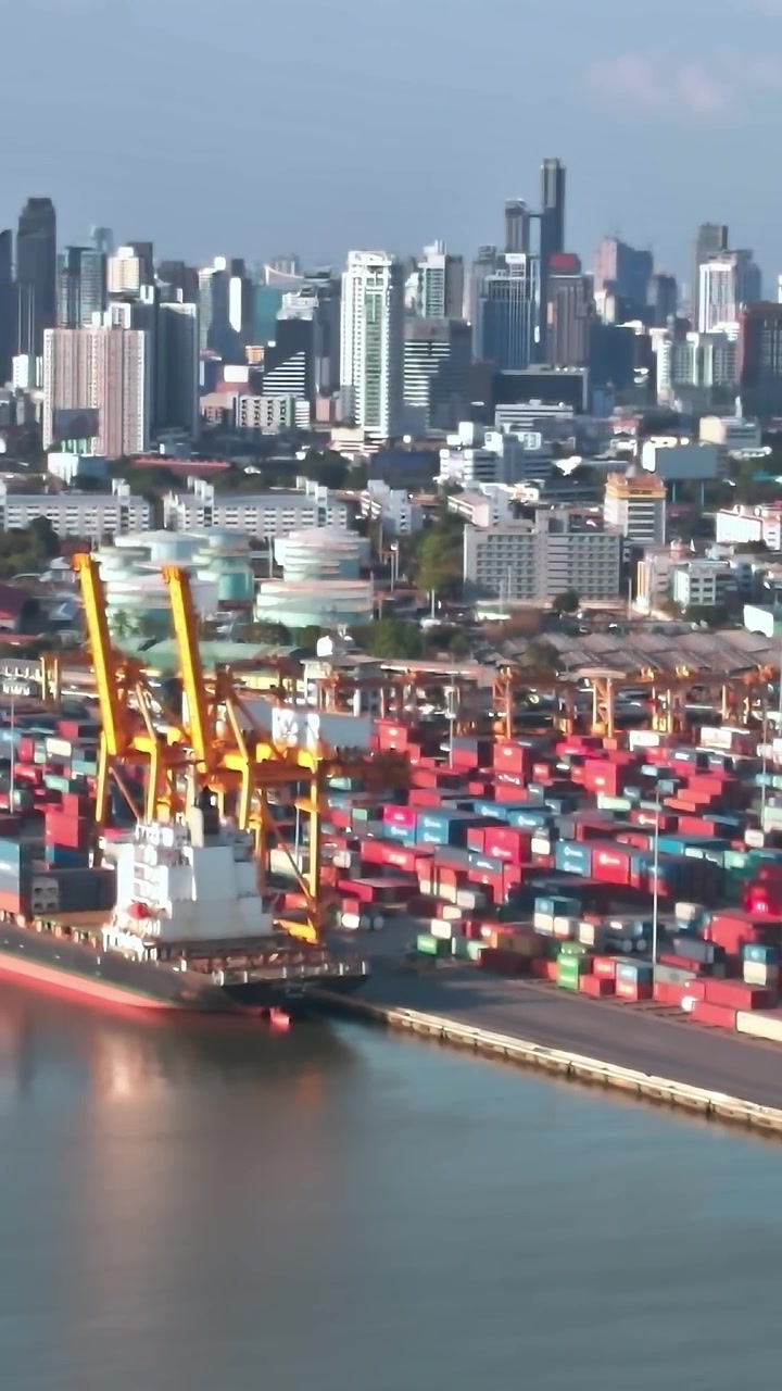 View of Bangkok skyline with shipping containers along the river