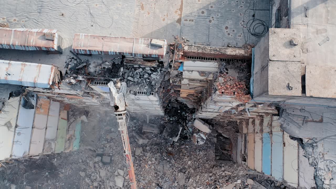 Clearing damage on a construction site using special equipment for a tractor. Demolition of a multi-storey building. Construction garbage