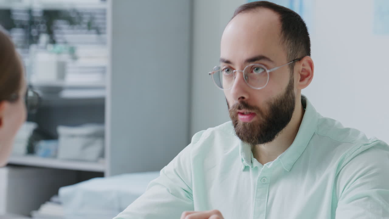 Man Signing Medical Agreement during Consultation with Doctor at Clinic