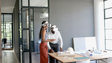 using vr headsets, diverse colleagues collaborating on architectural project in office
