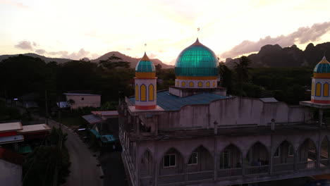 fotografía aérea de la mezquita asiática en tailandia , ao nang durante la puesta del sol y la luz del sol brillando a través de los vidrios de la cúpula azul